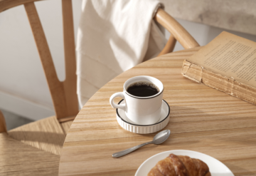 Tisch mit Kaffeetasse und Gebäck