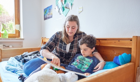 Erzieherin und Kind beim gemeinsamen Lesen